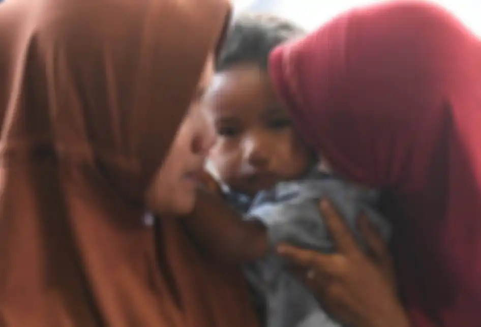 Pengungsi korban konflik di Wamena menggendong anaknya setibanya di Lanud Halim Perdanakusuma, Jakarta, Kamis (3/10/2019). Sebanyak 51 korban konflik di Wamena tersebut dievakuasi dengan menggunakan pesawat hercules C130 milik TNI Angkatan Udara.