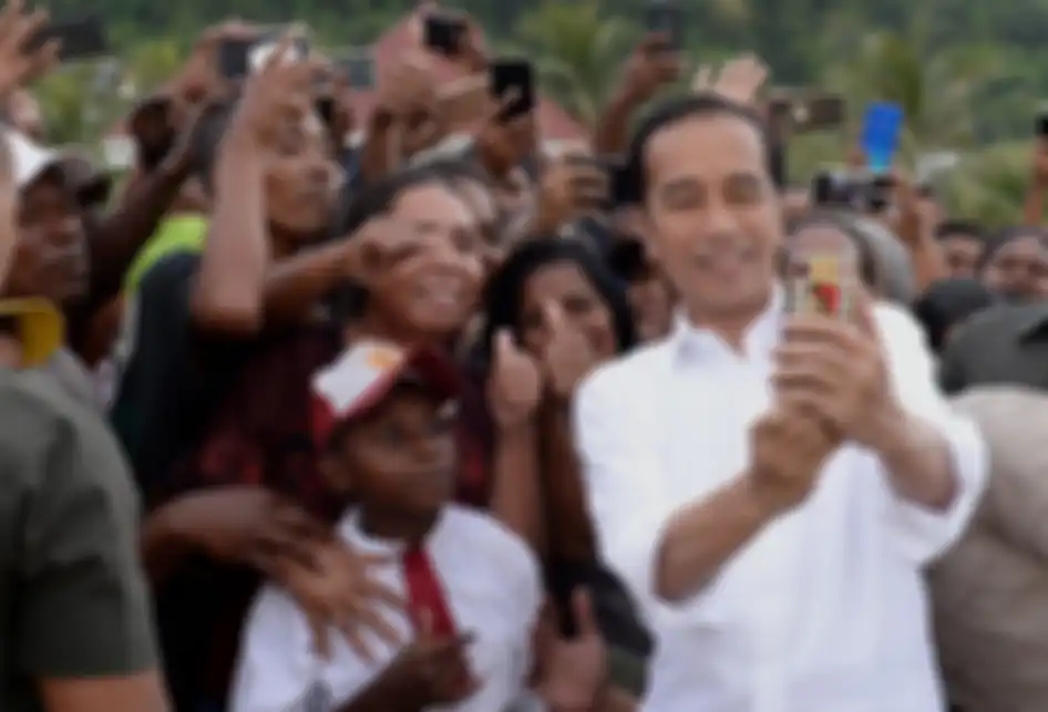 Presiden Joko Widodo atau akrab disapa Jokowi, berswafoto bersama warga yang menyambut kunjungannya di Kabupaten Kaimana, Papua Barat, Minggu (27/10/2019). Dalam kunjungannya, Jokowi dan Ibu Negara Iriana menikmati senja di Kaimana dengan duduk di tepi anjungan Laut Arafuru saat langit mulai memerah