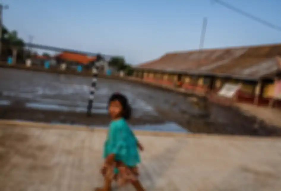 Seorang anak melintas di halaman SDN Pantai Bahagia 04 yang tergenang luapan air laut di Kampung Beting, Desa Pantai Bahagia, Kecamatan Muara Gembong, Kabupaten Bekasi, Jawa Barat, Kamis (28/11/2019). Ratusan rumah hunian warga alami kerusakan yang cukup parah, sehingga banyak rumah yang ditinggalka