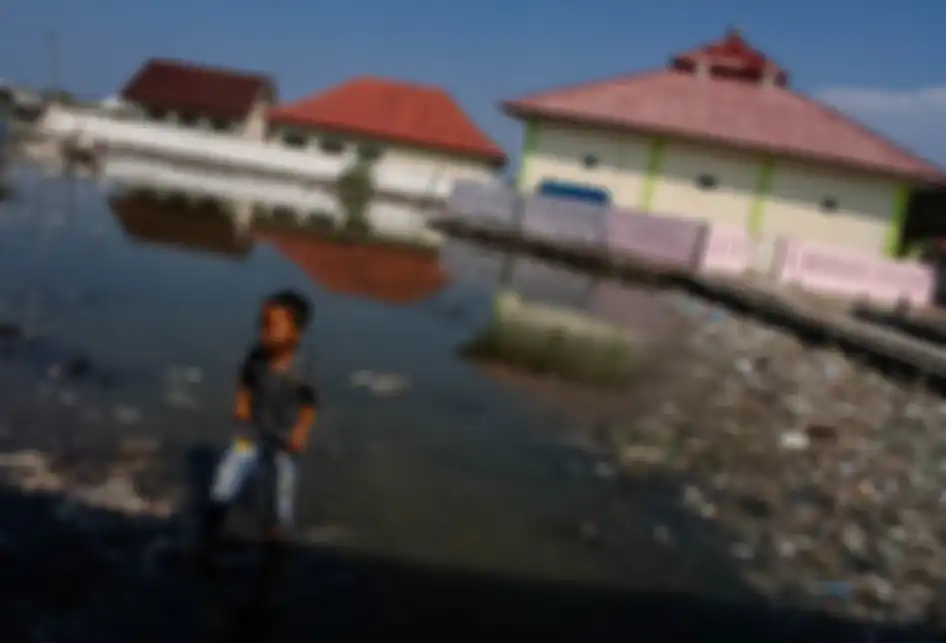 Seorang anak bermain di Lapangan yang tergenang luapan air laut di Muara Jaya, Desa Pantai Mekar, Kecamatan Muara Gembong, Kabupaten Bekasi, Jawa Barat, Kamis (28/11/2019). Ratusan rumah hunian warga alami kerusakan yang cukup parah, sehingga banyak rumah yang ditinggalkan pemiliknya.