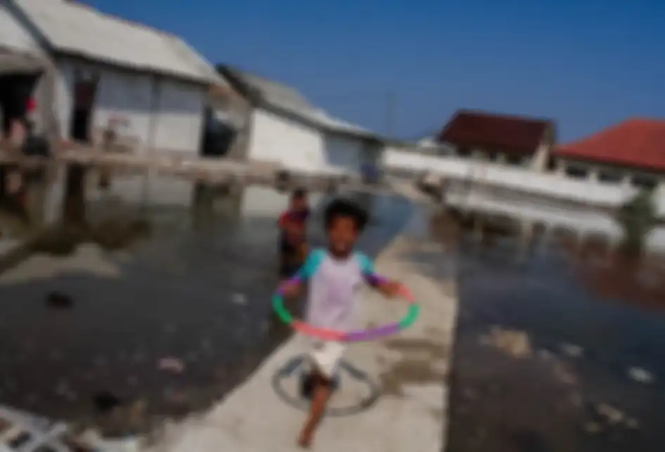 Sejumlah anak bermain di Lapangan yang tergenang luapan air laut di Muara Jaya, Desa Pantai Mekar, Kecamatan Muara Gembong, Kabupaten Bekasi, Jawa Barat, Kamis (28/11/2019). Ratusan rumah hunian warga alami kerusakan yang cukup parah, sehingga banyak rumah yang ditinggalkan pemiliknya.