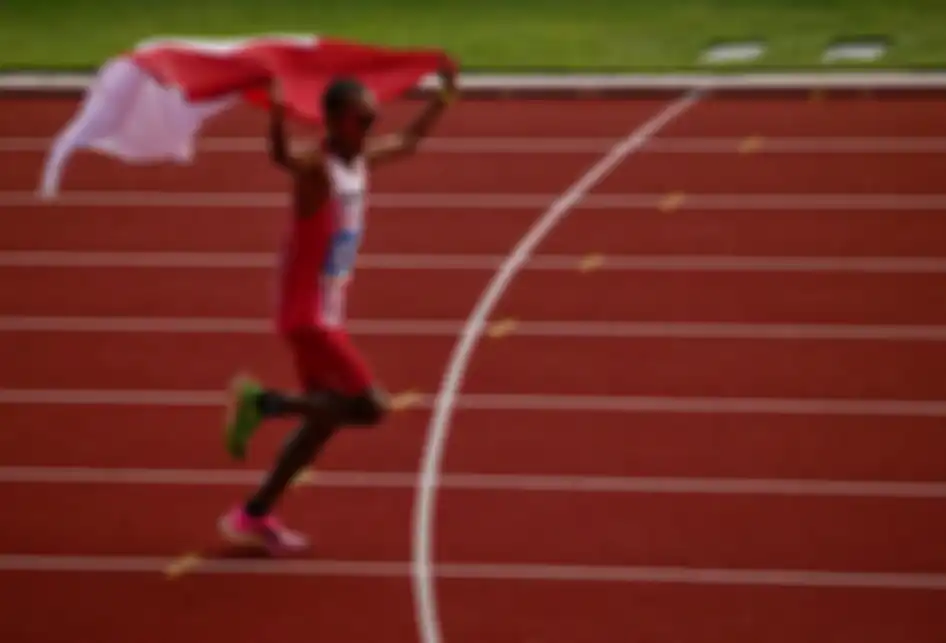 Pelari Indonesia Agus Prayogo mengibarkan bendera Merah Putih saat memasuki garis finish nomor marathon putra SEA Games 2019 di Stadion Atletik New Clark City, Clark, Filipina, Jumat (6/12/2019). Agus berhasil menyumbangkan medali emas pertama cabang atletik setelah menyelesaikan lomba sepanjang 42k