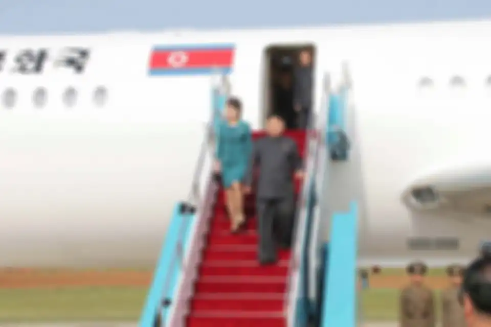 Pemimpin Korea Utara, Kim Jong Un dan istrinya Ri Sol Ju menuruni tangga peswat pribadinya. 