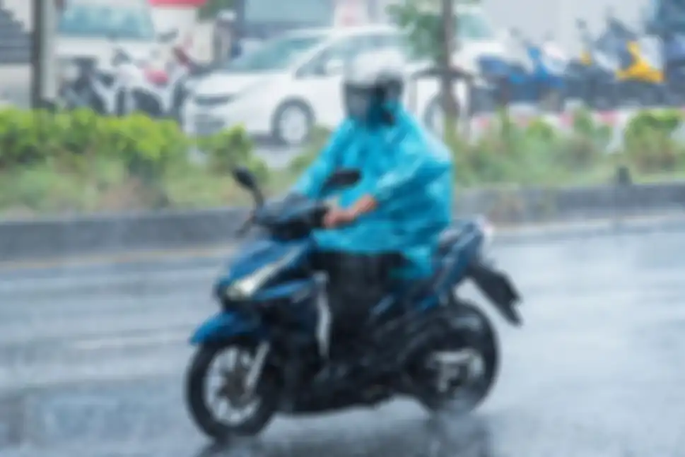 Ilustrasi berkendara motor saat hujan.
