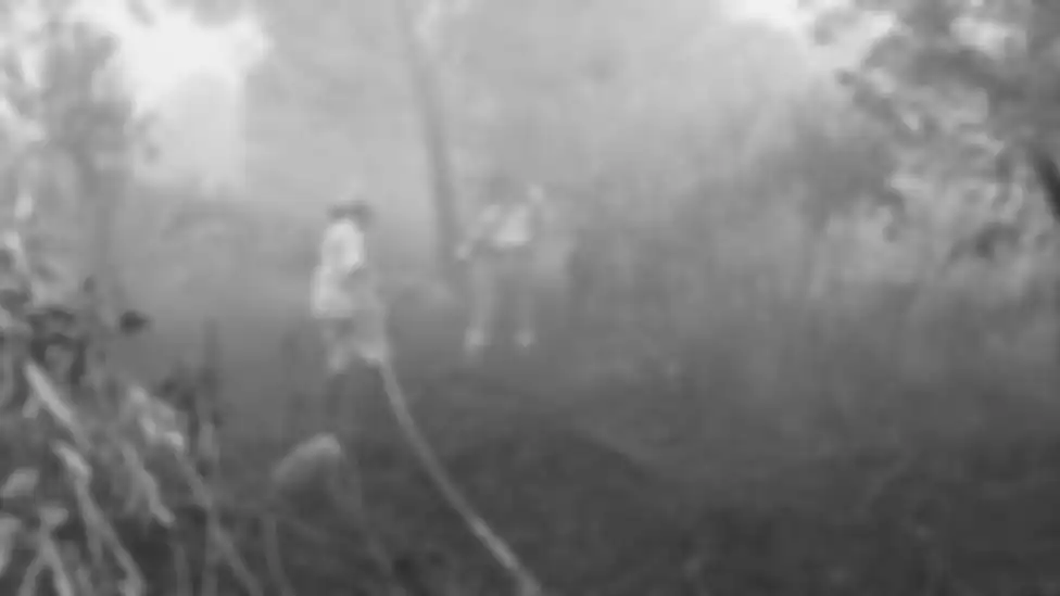 Sumarni (kiri) menarik selang untuk melancarkan aliran air dalam upaya pemadaman salah satu titik api di Palangkaraya, Kalimantan Tengah (18/09) 