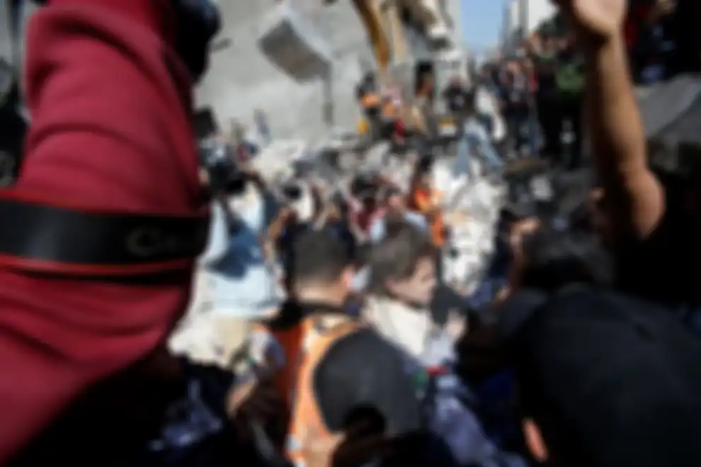 Warga Palestina mengevakuasi gadis cilik dari puing-puing rumah yang hancur setelah serangan udara Israel di Kota Gaza pada 16 Mei 2021.