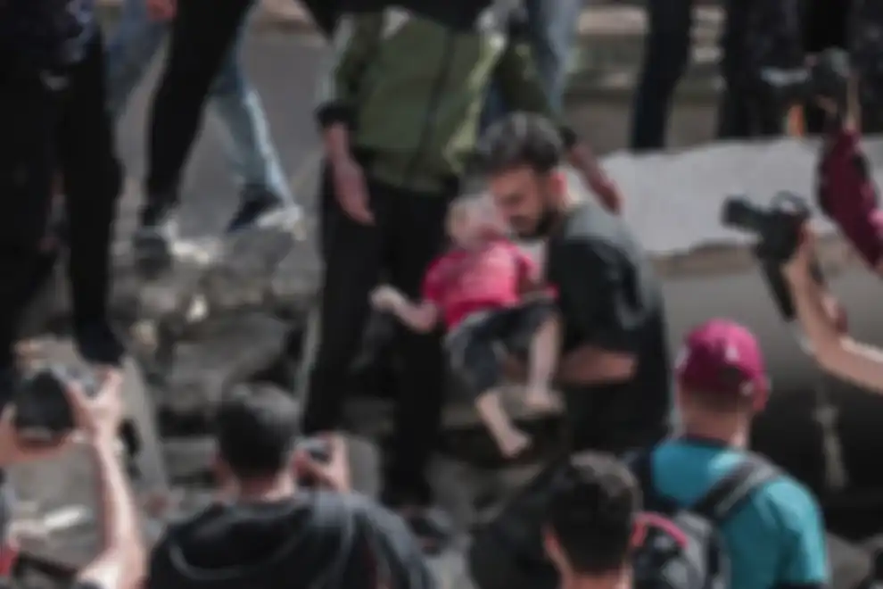 Warga Palestina mengevakuasi gadis cilik dari puing-puing rumah yang hancur setelah serangan udara Israel di Kota Gaza pada 16 Mei 2021. 