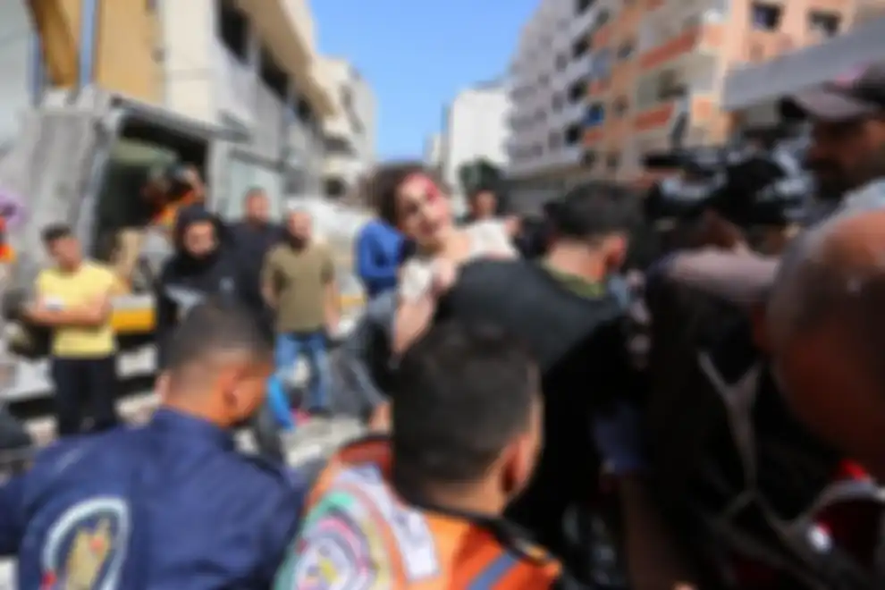 Warga Palestina menyelamatkan Suzy Eshkuntana yang berusia 6 tahun dari puing-puing rumahnya setelah serangan udara oleh tentara Israel di lingkungan al-Rimal Kota Gaza, Gaza, pada 16 Mei 2021.