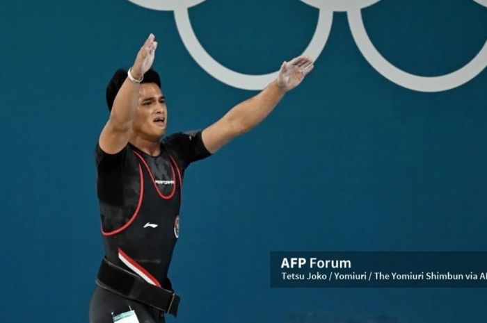 Atlet angkat besi Indonesia Rizki Juniansyah mengangkat tangan haru penuh sukacita seusai berhasil merebut medali emas kelas 73 kg putra Olimpiade Paris 2024.