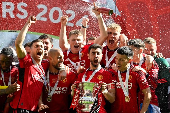 Gelandang Manchester United Bruno Fernandes mengangkat trofi untuk selebrasi juara Piala FA bersama rekan-rekannya seusai mengalahkan Manchester City di Stadion Wembley, London, 25 Mei 2024.