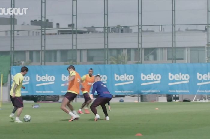 Megabintang Barcelona, Lionel Messi (kiri), mengelabui bek Gerard Pique dalam sesi latihan El Barca.