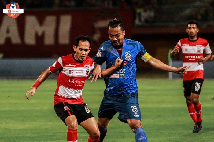 Pemain Madura United, Slamet Nurcahyo, berduel dengan bek Arema FC, Hamka Hamzah, pada laga pekan kesepuluh Liga 1 2019 di Stadion Gelora Madura, Sabtu (20/7/2019).