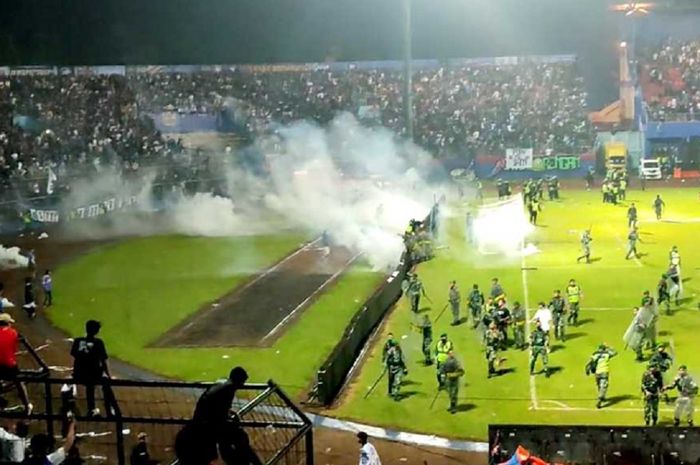 Polisi menembakkan gas air mata ke arah suporter seusai laga Liga 1 antara Arema FC dan Persebaya Surabaya di Stadion Kanjuruhan, Malang,  Sabtu (1/10/2022) malam.