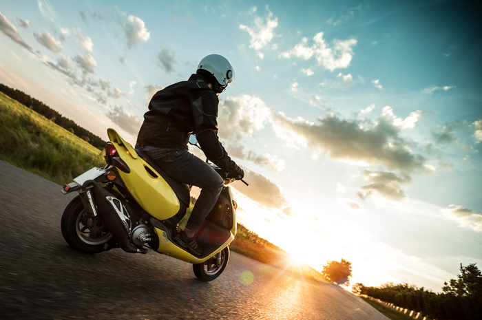 Ilustrasi mengendarai motor matic