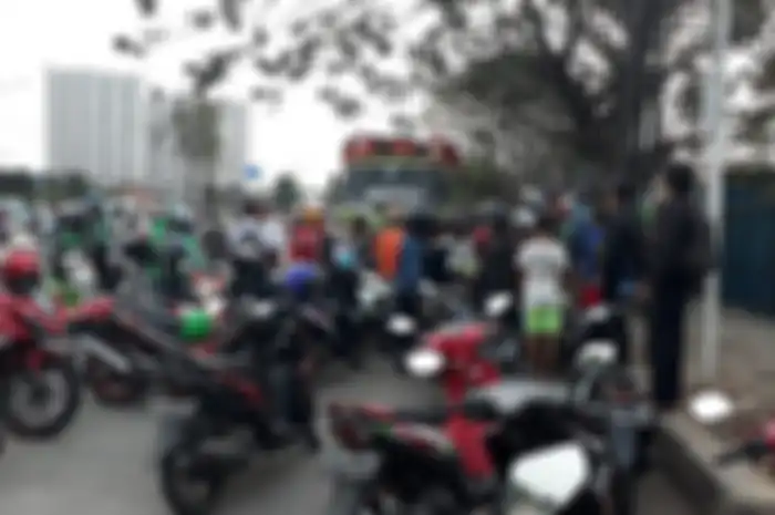 Kerumunan pemotor membantu belasan motor yang terjatuh