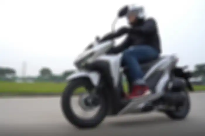 Ilustrasi mengendarai motor matik