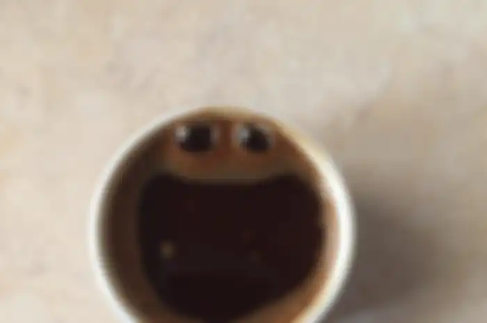 Segelas kopi yang membangkitkan pareidolia, imaji kita tentang wajah manusia.  