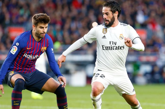 Pemain Real Madrid, Isco, berusaha melewati bek Barcelona, Gerard Pique, pada laga El Clasico, Oktober 2018.