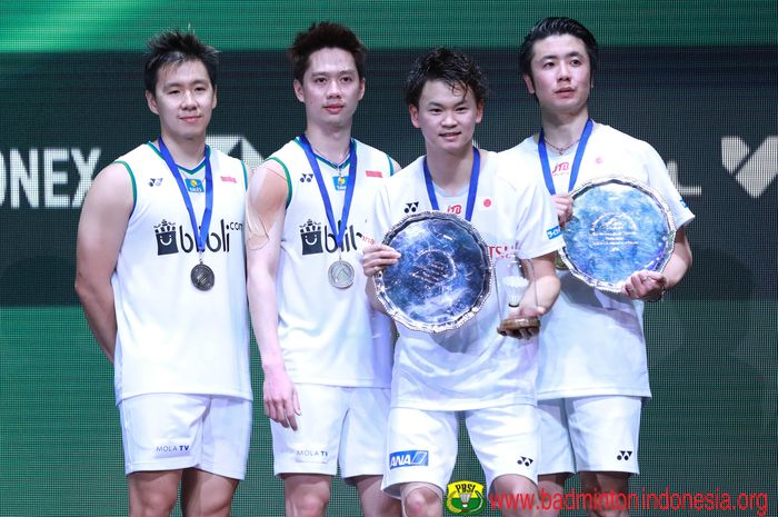 Pasangan ganda putra Indonesia, Marcus Fernaldi Gideon/Kevin Sanjaya Sukamuljo (kiri), berpose bersama Hiroyuki Endo/Yuta Watanabe (Jepang) di atas podium kampiun All England Open 2020,  Arena Birmingham, Inggris, Minggu (15/3/2020).