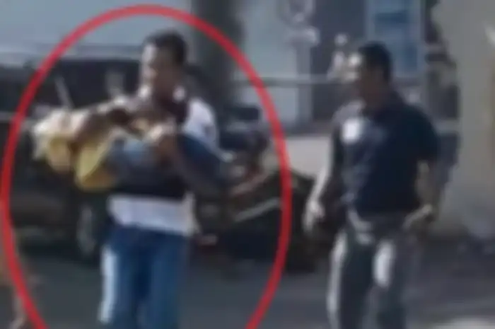 Seorang polisi menyelamatkan anak kecil usai ledakan bom di Polrestabes Surabaya.