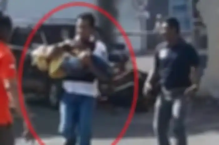 Seorang polisi menyelamatkan anak kecil usai ledakan bom di Polrestabes Surabaya.