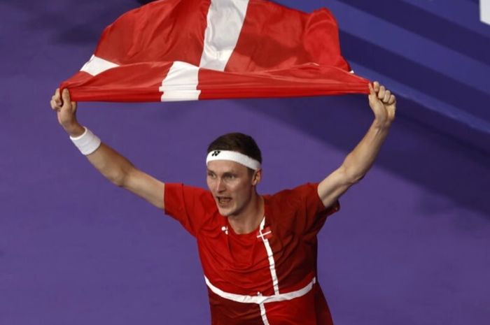 Viktor Axelsen mengitari arena sambil membawa bendera Denmark seusai menjuarai tunggal putra bulu tangkis Olimpiade Paris 2024, Senin (5/8/2024) malam WIB.