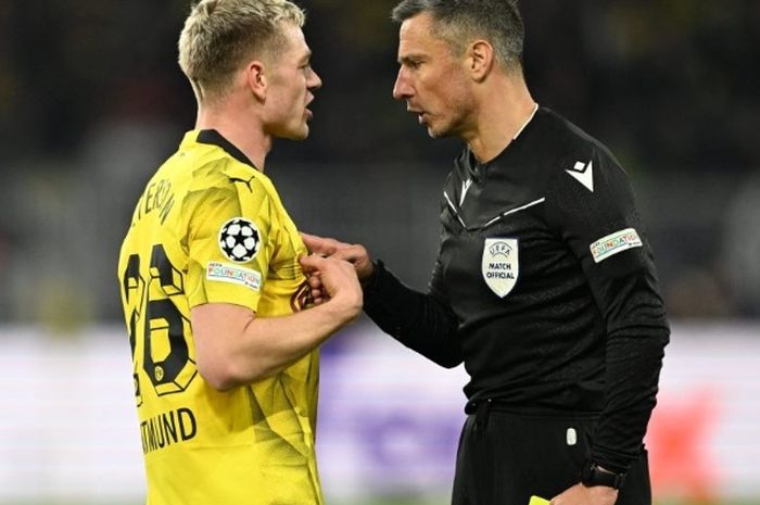 Wasit Slavko Vincic menghukum sayap Borussia Dortmund Julian Ryerson kartu kuning dalam leg kedua perempat final Liga Champions melawan Atletico Madrid pada 16 April 2024.