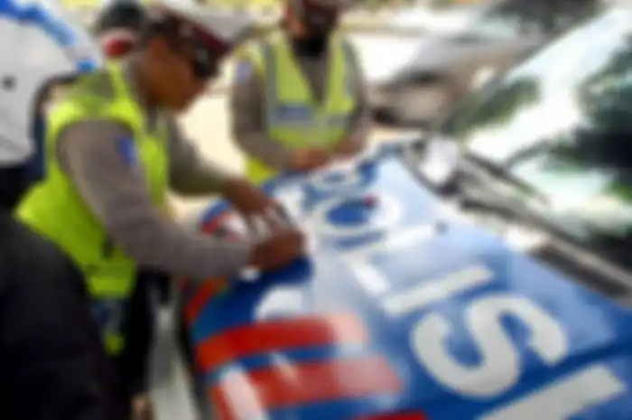 Ilustrasi polisi sedang bertugas memberikan surat tilang