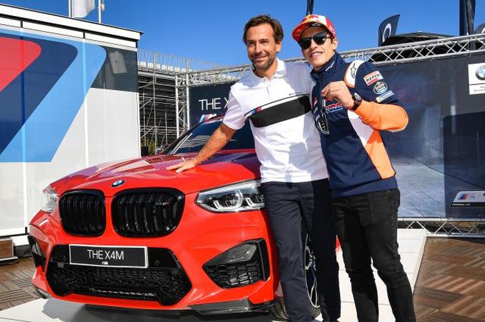 Pembalap Repsol Honda, Marc Marquez (kanan), menerima hadiah mobil BMW X4 M Competition setelah meraih poin terbanyak dari sesi kualifikasi pada MotoGP 2019.