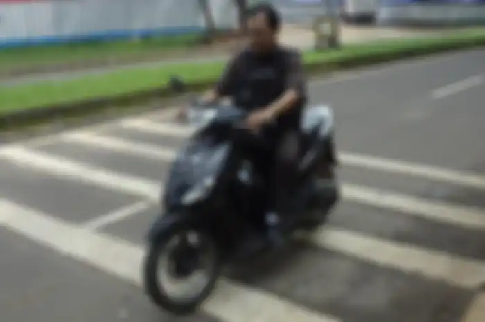 Ilustrasi pemotor melewati polisi tidur.