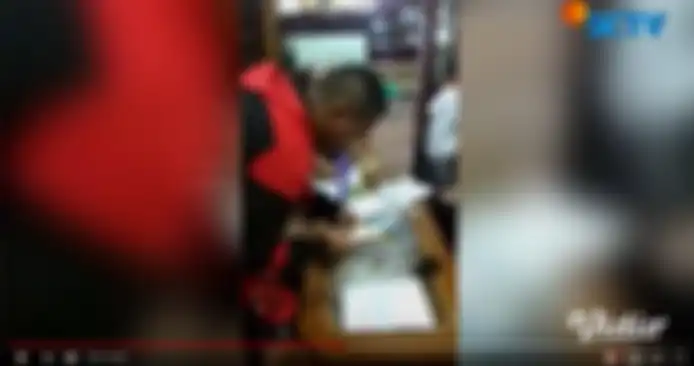 Teddy tampak memotret surat yang telah ditanda tangani Putri Delina