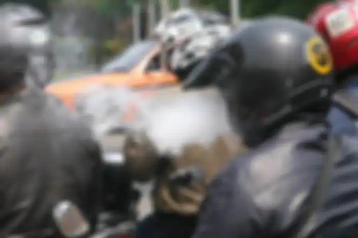 Naik motor sambil merokok  mengganggu orang lain