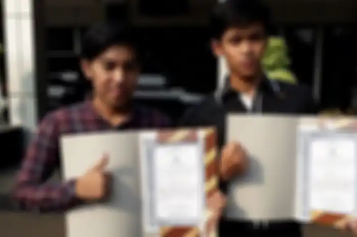 Ahmad Rafiki dan Mohamad Irfan Bahri berpose dengan piagam penghargaan yang diterimanya di Lapangan Mapolres Metro Bekasi Kota, Bekasi, Kamis (31/5/2018). 