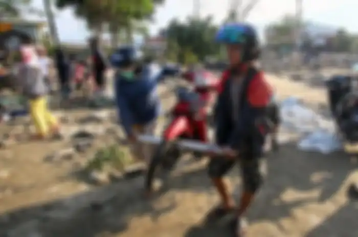 Korban gempa bumi menyelamatkan motor.
