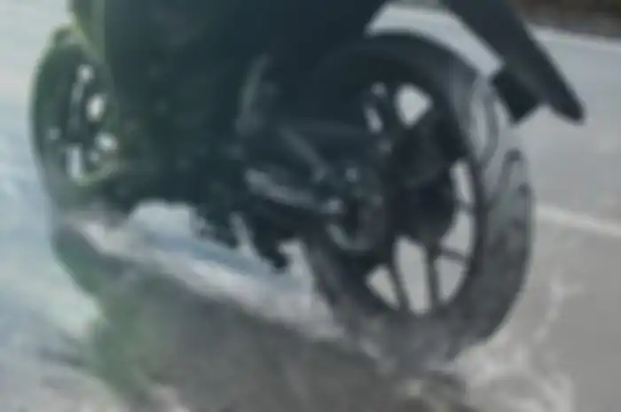 Sepeda motor melibas jalanan basah di musim hujan