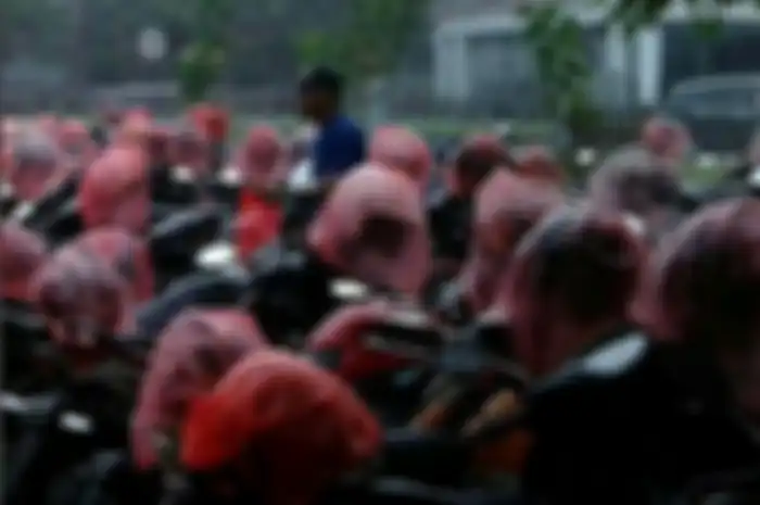 Juru parkir ini rela kehujanan demi mengamankan helm bikers