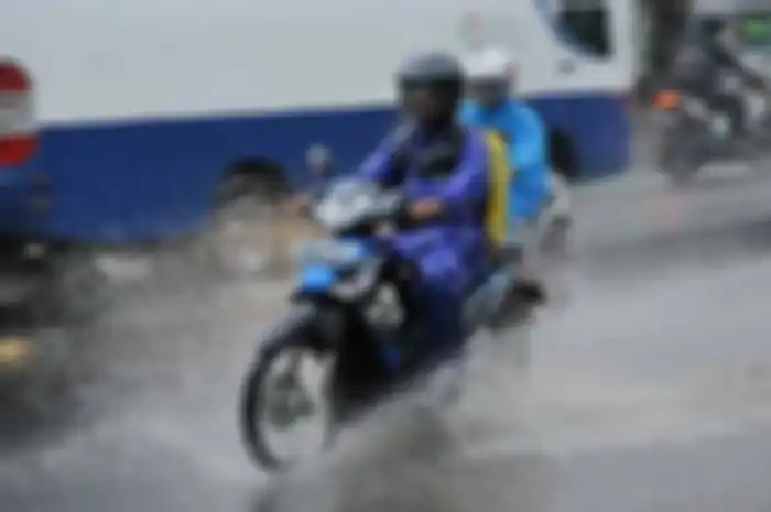Mengendarai motor saat hujan harus tetap waspada