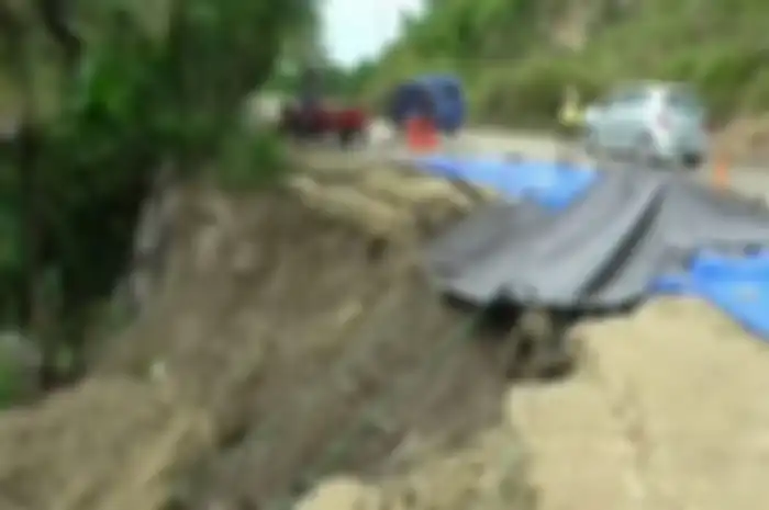 Jalan ambles sepanjang 30 meter di Desa Soreang Palipi, Kecamatan Banggae, Majene, Sulawesi Barat, hanya ditutupi terpal untuk hindari pengendara terperosok jurang 