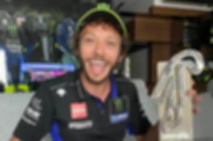 Valentino Rossi gasak podium 3 di MotoGP Virtual Race langsung selebrasi angkat trofi udah kayak podium MotoGP beneran. Eh, trofinya asli benera trofi MotoGP San Marino lo