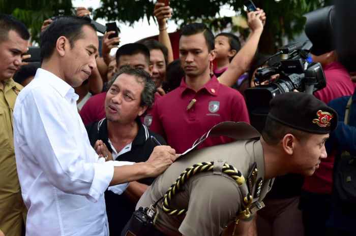 Presiden Jokowi pinjam punggung ajudan.