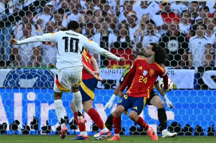 Bola tendangan keras gelandang Jerman Jamal Musiala diblokir tangan bek Spanyol Marc Cucurella di kotak penalti dalam perempat final Euro 2024 di Stuttgart Arena, Jumat (5/7/2024). Wasit Anthony Taylor tak memberikan hadiah penalti kepada Jerman, bahkan tak ada review VAR. 