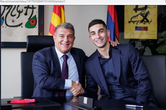 Ferran Torres berpose dengan presiden Barcelona, Joan Laporta.