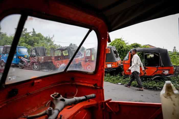 Warga berjalan di dekat bangkai bajaj oranye di kawasan Cideng, Jakarta, Senin (5/3/2018). Bajaj ora