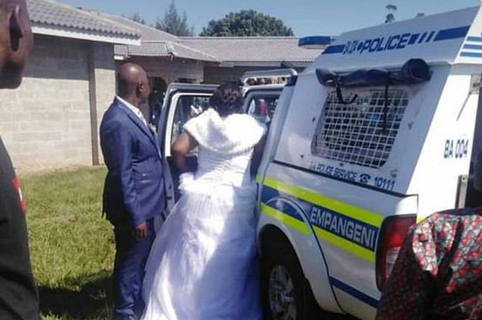 Masih mengenakan setelan jas dan gaun pengantin, pasangan ini diciduk polisi bersenjata yang menyerbu upacara pernikahan mereka
