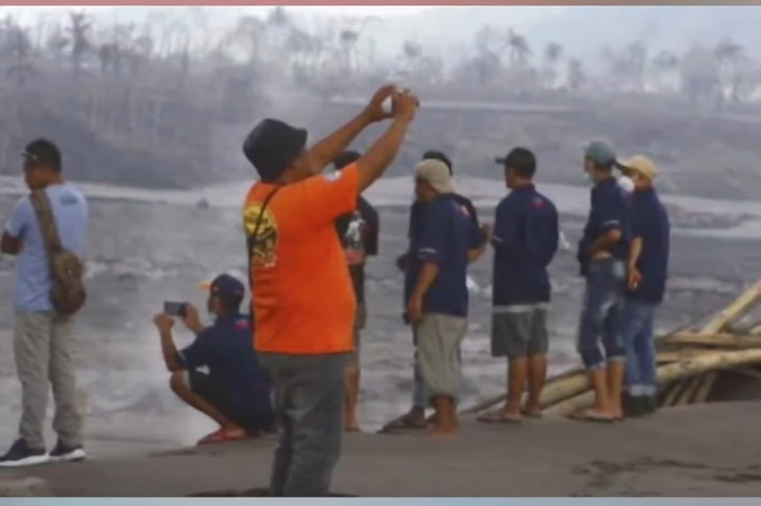 Salah satu masyarakat yang datang ke lokasi terdampak erupsi gunung Semeru untuk berfoto selfie
