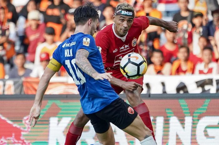 Pemain PSM Makassar mencoba menghalau tendangan pemain Persija Jakarta, Bruno Matos di Stadion Utama Gelora Bung Karno (SUGBK), Minggu (21/7/2019).