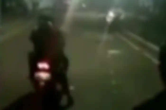 Pemotor dengan boncengan cuek aja jalan di bawah melesatnya gas air mata