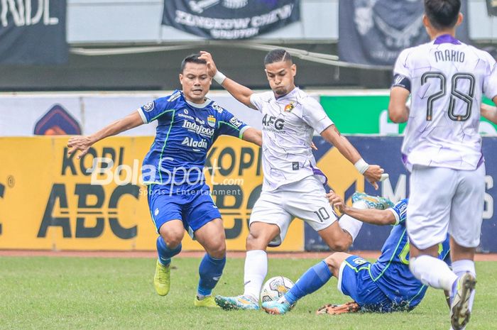 Gelandang Persik Kediri, Renan Silva (tengah), sedang menguasai bola dan dibayangi pemain Persib Bandung bernama Dedi Kusnandar (kiri) dalam laga pekan ke-29 Liga 1 2022 di Stadion Pakansari, Bogor, Jawa Barat, Rabu (8/3/2023).