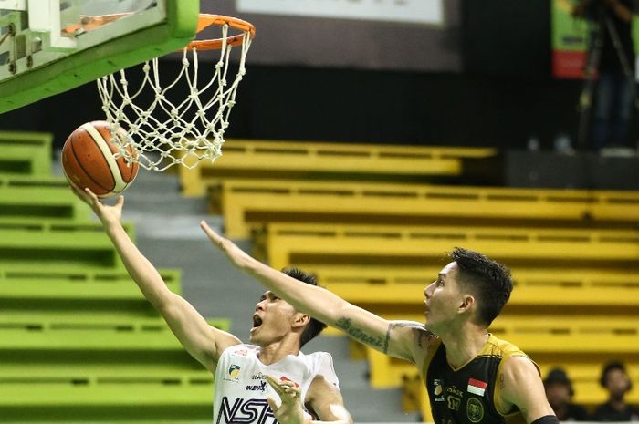 Pemain NSH Jakarta Andre Rorimpandey (putih) berupaya memasukkan bola ke ring pada laga seri ke-6 IBL Pertamax 2018-2019 melawan Bogor Siliwangi, di GOR Pacific, Surabaya, Minggu (3/2/2019) siang.