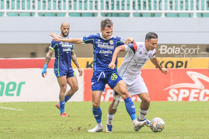 Bek sayap kiri Persib Bandung, Rezaldi Hehanussa (kiri), sedang merebut bola yang dikuasai pemain Arema FC bernama Dendi Santoso (kanan) dalam laga pekan ke-26 Liga 1 2022 di Stadion Pakansari, Bogor, Jawa Barat, Kamis (23/2/2023).